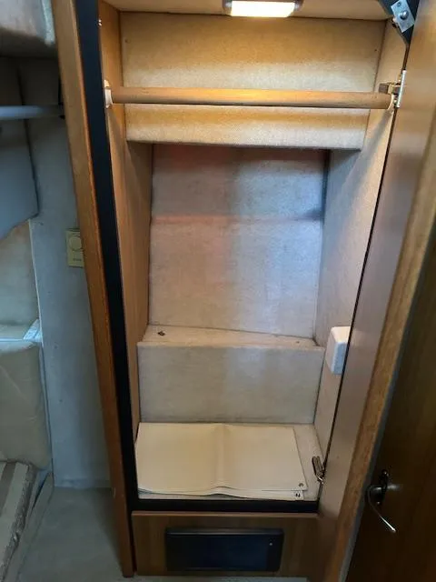 Slide: The Image of Empty closet inside 2002 Bayliner 3988 Command Bridge Motoryacht, featuring wooden finish and interior lighting. - 9