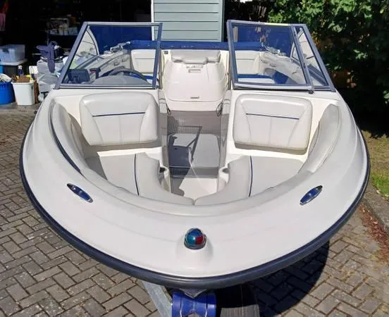 Slide: The Image of 2007 Bayliner 195 boat with open bow seating, parked on a brick driveway. - 3