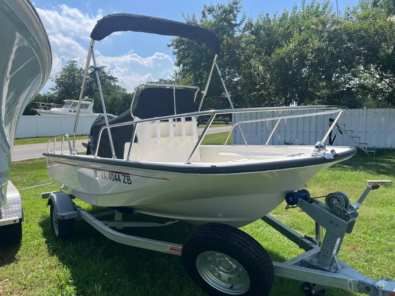 Slide: The Image of 2025 Boston Whaler 150 Montauk boat on trailer, parked on grass. - 16