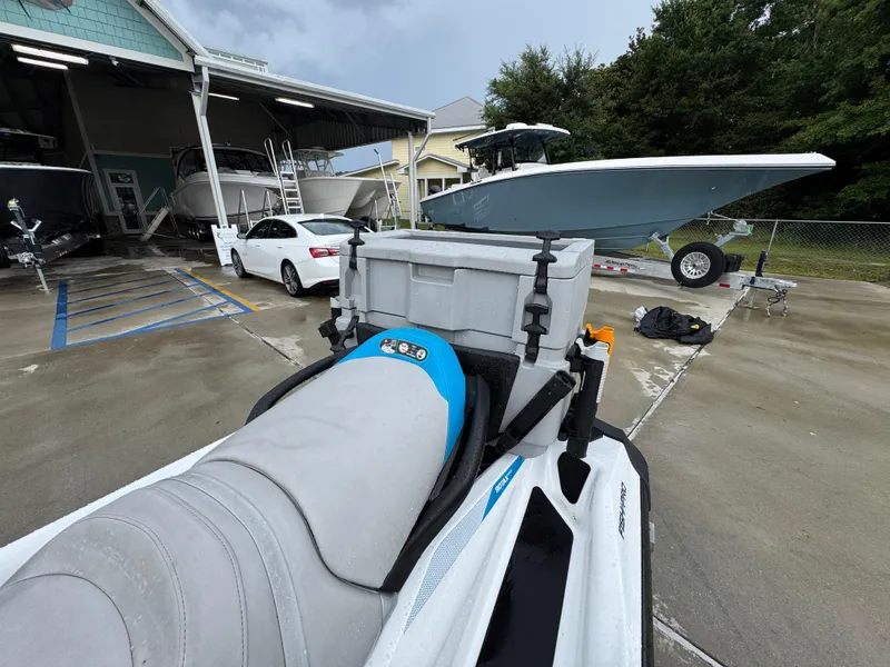 Slide: The Image of 2022 Sea-Doo Fish Pro Scout parked near boats and vehicles at a marina. - 18