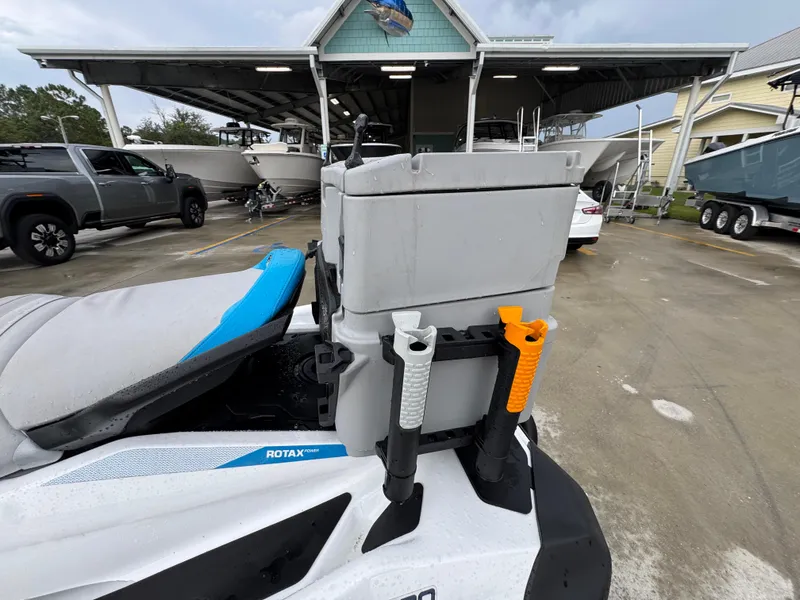 Slide: The Image of 2022 Sea-Doo Fish Pro Scout with fishing gear, parked near boats and vehicles. - 19