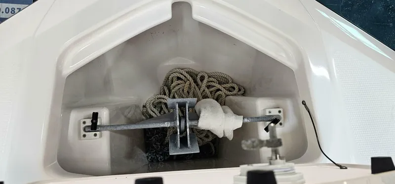 Slide: The Image of Anchor storage compartment on 2018 Yamaha Boats 210 FSH Deluxe with coiled rope. - 11