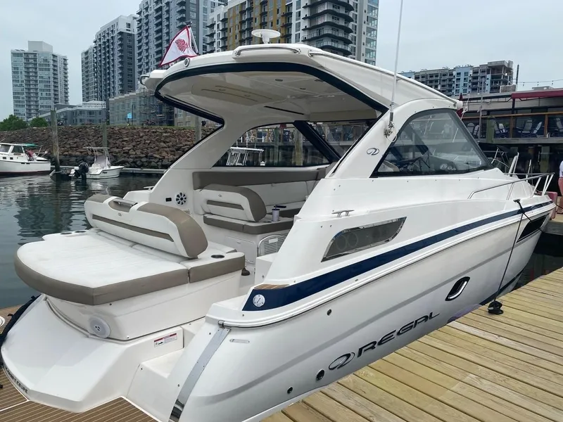 Slide: The Image of 2016 Regal 35 Sport Coupe docked at marina with cityscape background. - 4