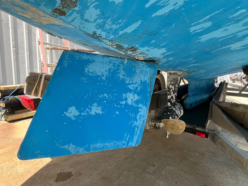 Slide: The Image of Underside of a 2004 Custom Sakonnet 23 boat with blue paint and visible rudder. - 13