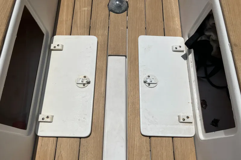Slide: The Image of Wooden deck of 2004 Custom Sakonnet 23 boat with white storage hatches. - 18