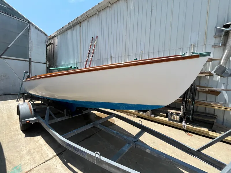 Slide: The Image of Custom Sakonnet 23 sailboat on trailer, 2004 model, parked near a metal building. - 9