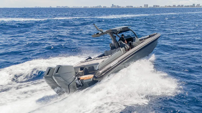 Slide: The Image of 2025 Skipper-BSK 38 boat cruising on open ocean with city skyline in background. - 17