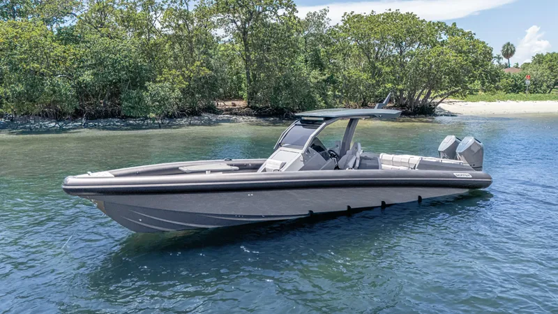 Slide: The Image of 2025 Skipper-BSK 38 boat on calm water near a lush shoreline. - 32