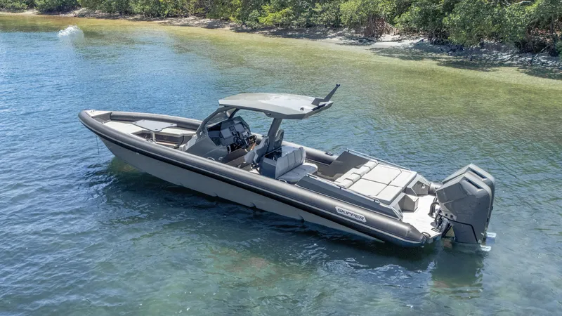 Slide: The Image of 2025 Skipper-BSK 38 boat on clear water near a lush shoreline. - 34