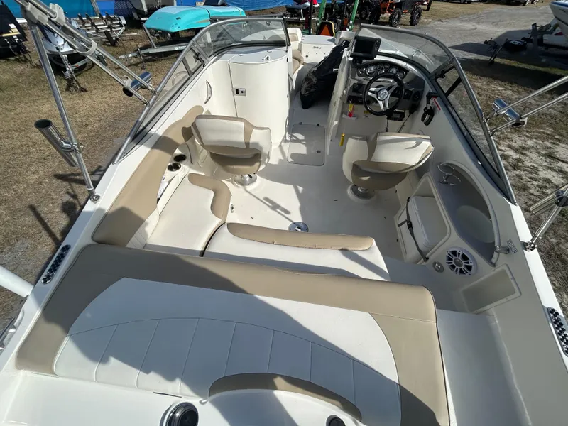 Slide: The Image of 2019 Stingray 240 LR boat interior with beige seating and modern dashboard. - 12