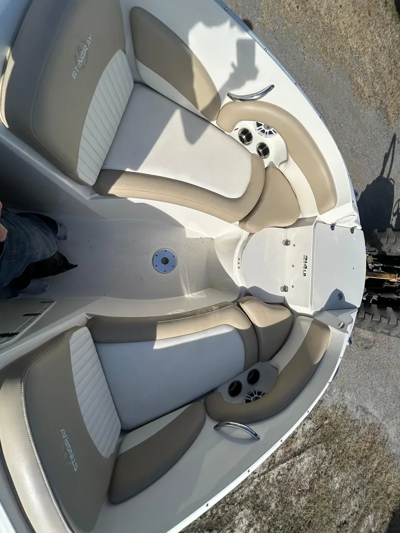 Slide: The Image of 2019 Stingray 240 LR boat interior with beige and white seating, cup holders, and sleek design. - 13
