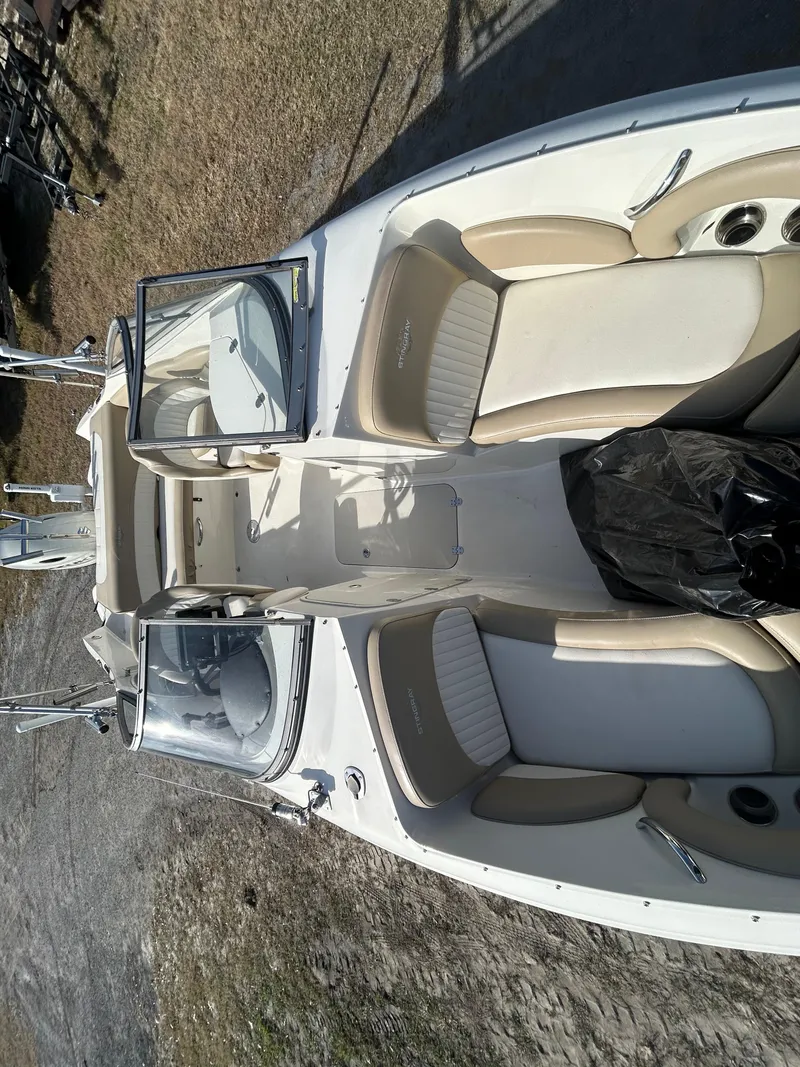 Slide: The Image of 2019 Stingray 240 LR boat with beige seating, parked on grass. - 16