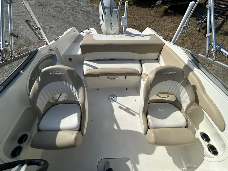 Slide: The Image of 2019 Stingray 240 LR boat interior with beige seating and cup holders. - 18