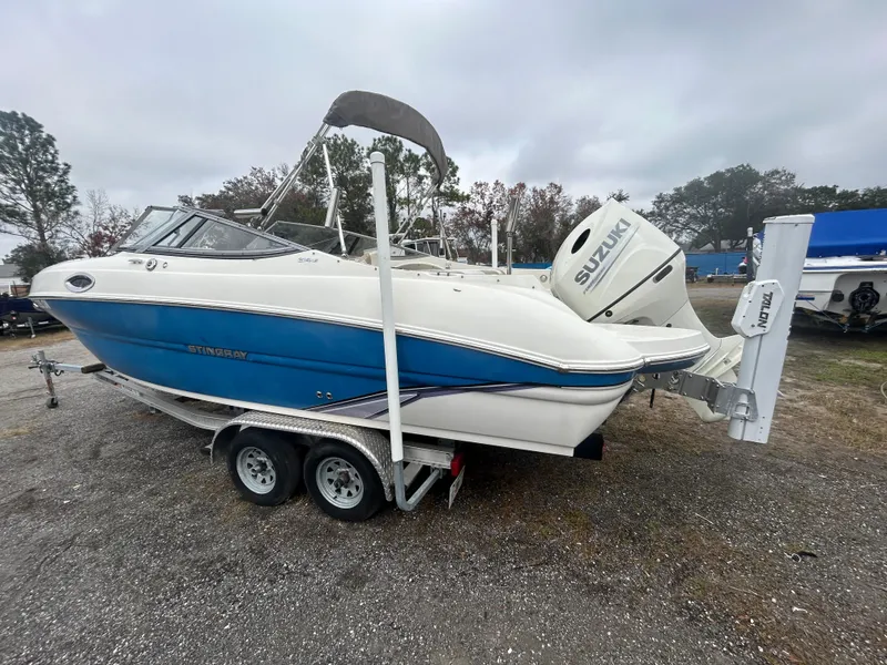 Slide: The Image of 2019 Stingray 240 LR boat with Suzuki outboard motor on a trailer. - 4