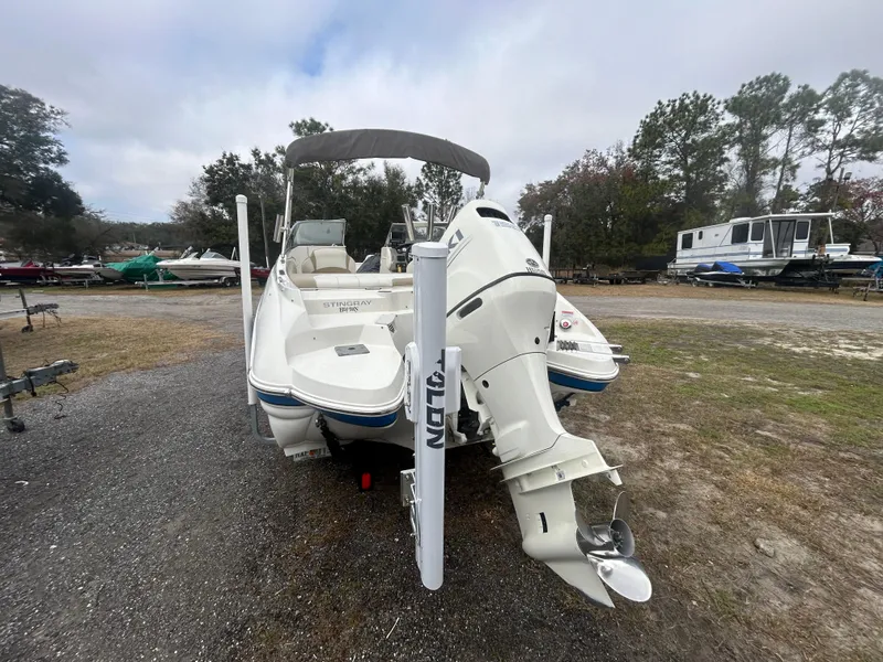 Slide: The Image of 2019 Stingray 240 LR boat with outboard motor in a marina setting. - 5