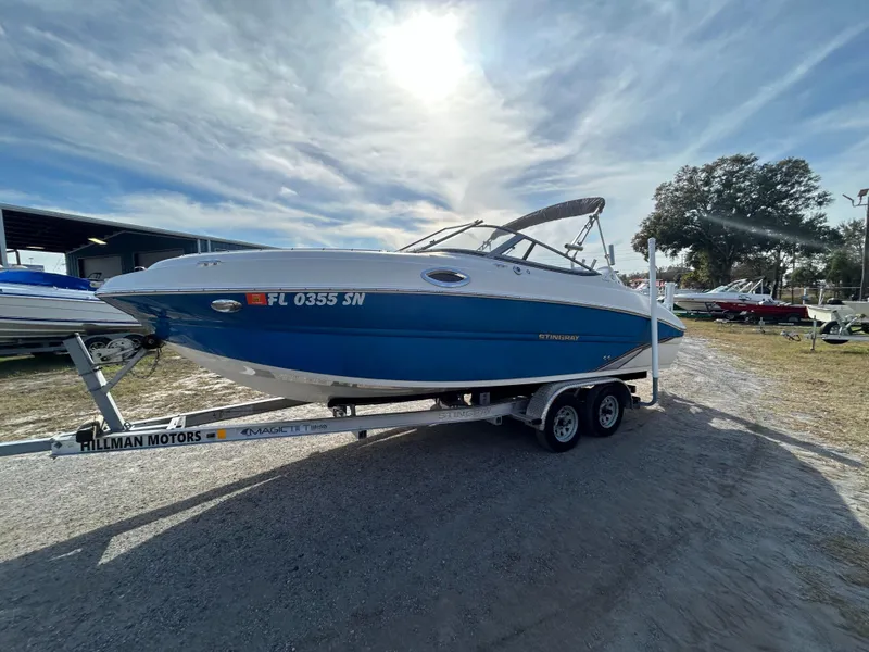 Slide: The Image of 2019 Stingray 240 LR boat on trailer under a bright sky. - 6