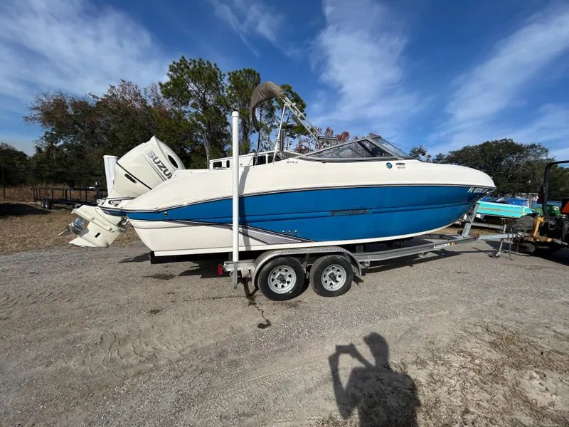 Slide: The Image of 2019 Stingray 240 LR boat on trailer, parked outdoors under blue sky. - 9