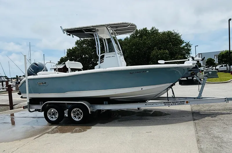 Slide: The Image of 2019 Sea Hunt Ultra 196 boat on trailer, parked near marina. - 10