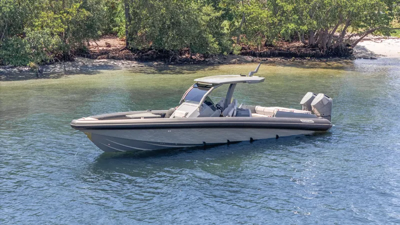 Slide: The Image of 2025 Skipper-BSK 38 boat on calm water near a lush shoreline. - 30