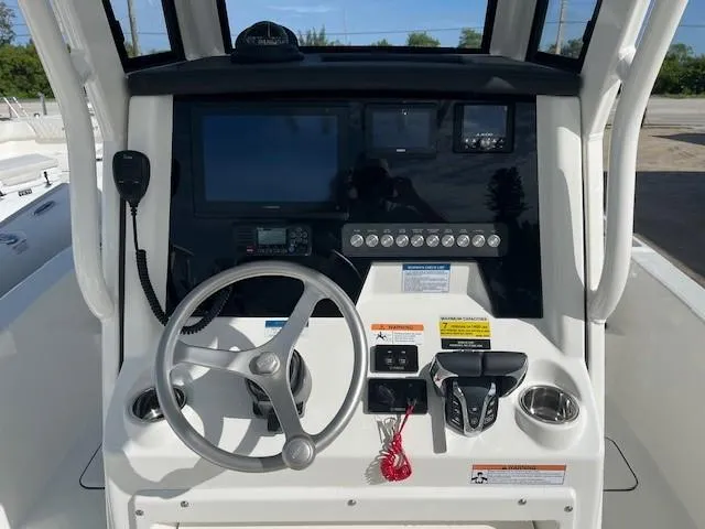 Slide: The Image of 2025 World Cat 235 CC boat console with steering wheel and navigation controls. - 5