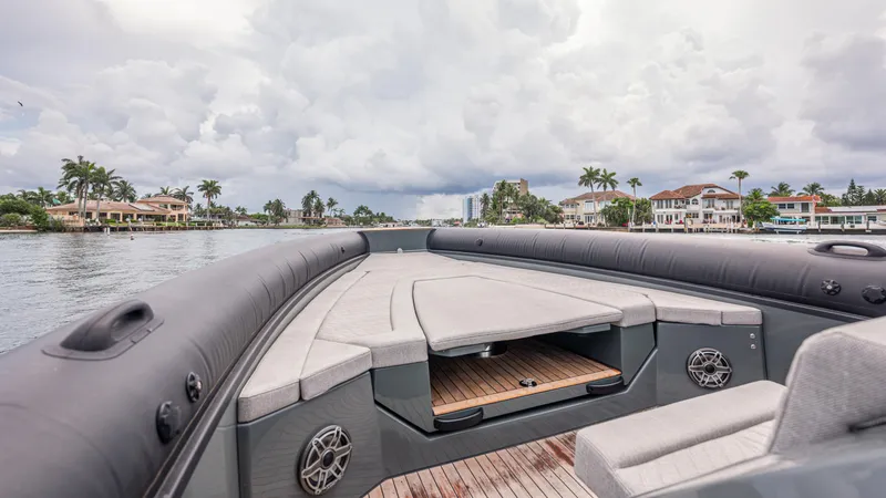Slide: The Image of 2025 Skipper-BSK 38 boat on water, cloudy sky, luxury waterfront homes in background. - 49