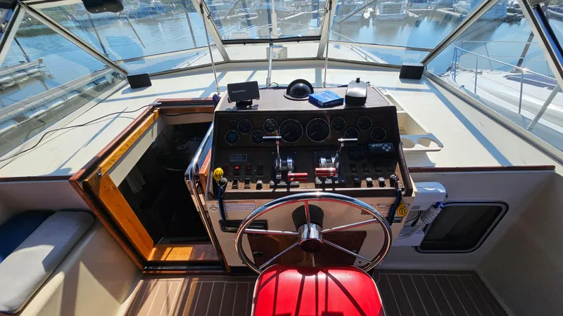 Slide: The Image of Helm of 1983 Chris-Craft 381 Catalina with steering wheel and control panel, docked at marina. - 10