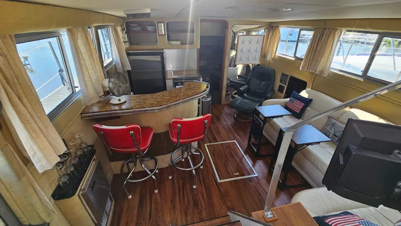 Slide: The Image of 1983 Chris-Craft 381 Catalina interior with bar, seating, and nautical decor. - 11