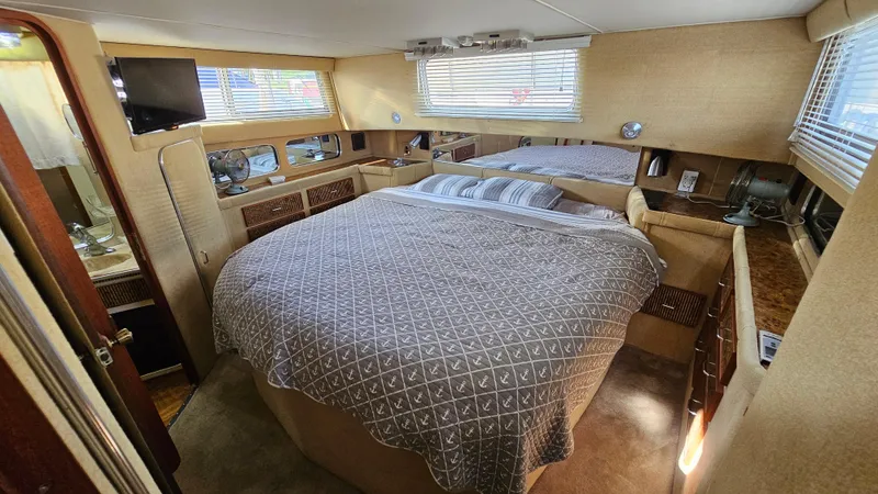 Slide: The Image of 1983 Chris-Craft 381 Catalina cabin interior with bed, TV, and windows. - 23
