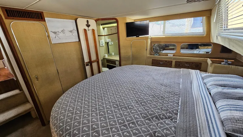 Slide: The Image of 1983 Chris-Craft 381 Catalina interior with cozy bedroom, nautical decor, and natural light. - 24