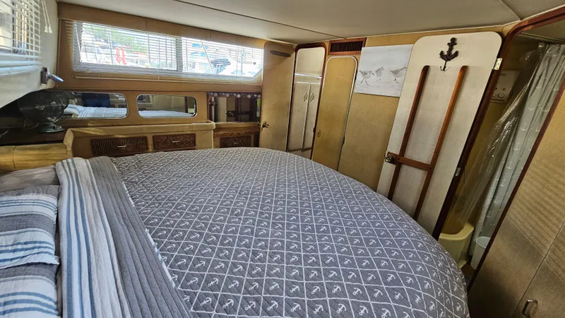 Slide: The Image of 1983 Chris-Craft 381 Catalina cabin interior with bed, wood accents, and nautical decor. - 25