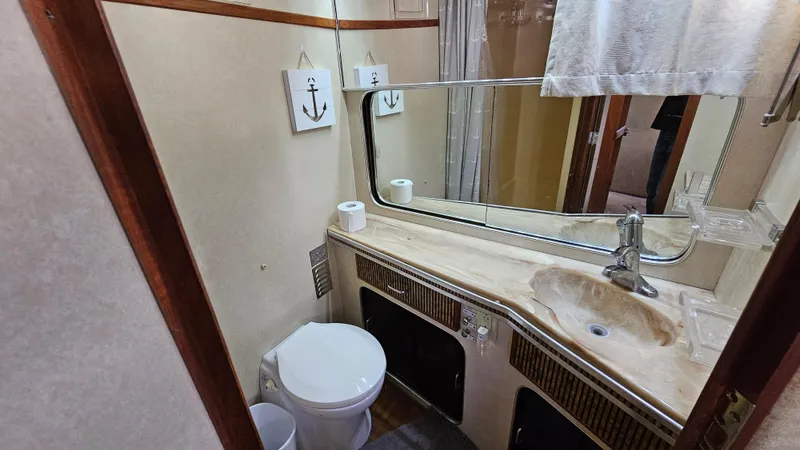 Slide: The Image of 1983 Chris-Craft 381 Catalina bathroom with sink, mirror, and nautical decor. - 26