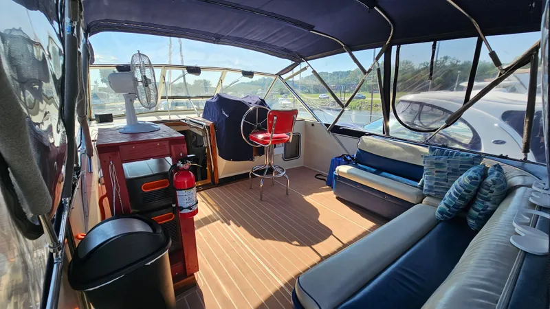 Slide: The Image of 1983 Chris-Craft 381 Catalina interior with seating, fan, and fire extinguisher on a sunny day. - 5