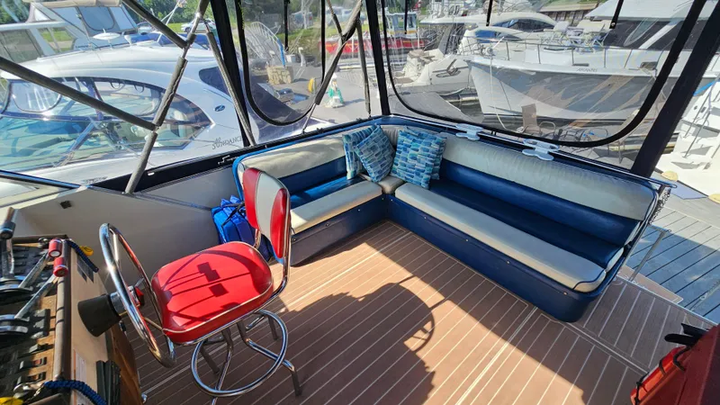 Slide: The Image of 1983 Chris-Craft 381 Catalina interior with seating and helm, docked at marina. - 6