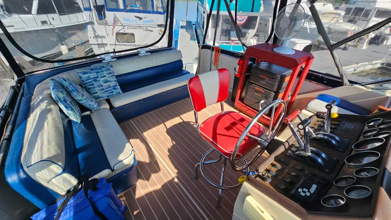 Slide: The Image of 1983 Chris-Craft 381 Catalina interior with blue seating, red chair, and control panel. - 7