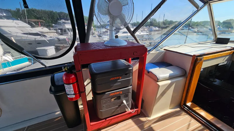 Slide: The Image of 1983 Chris-Craft 381 Catalina interior with fan, power station, and marina view. - 9
