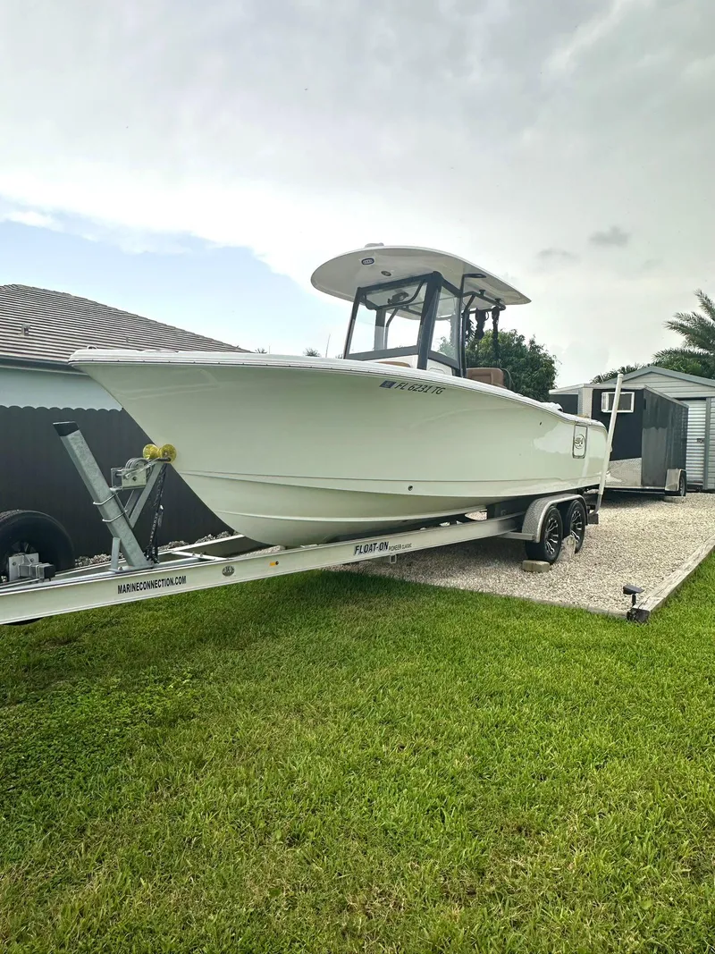 The Image of 2022 Sea Hunt Ultra 255 SE boat on trailer, parked on grass. - 0