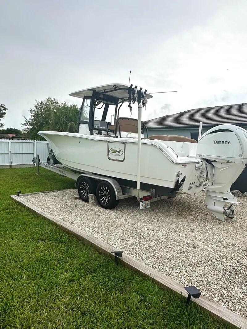 Slide: The Image of 2022 Sea Hunt Ultra 255 SE boat on trailer in a yard. - 1