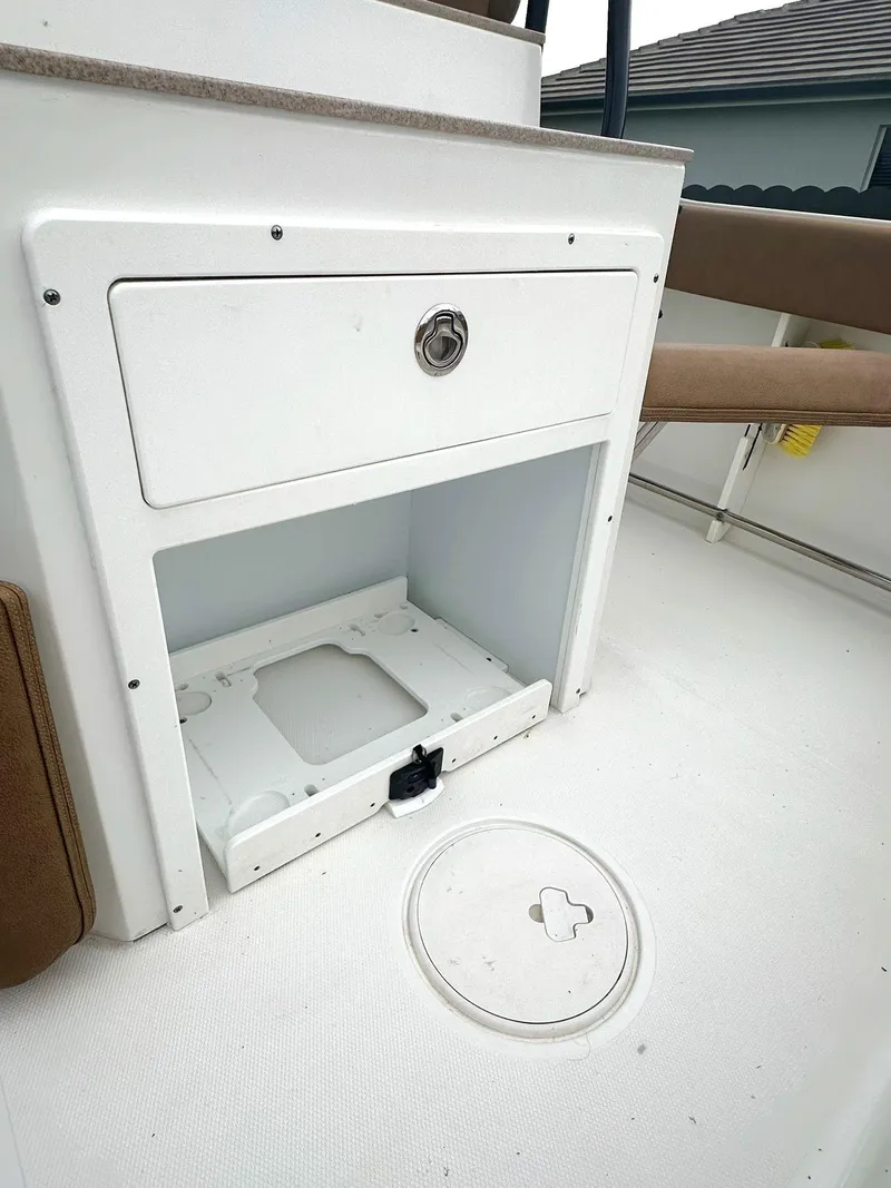Slide: The Image of 2022 Sea Hunt Ultra 255 SE boat storage compartment with open hatch and seating area. - 11