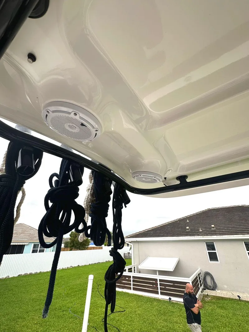 Slide: The Image of 2022 Sea Hunt Ultra 255 SE boat with speakers and ropes, residential background. - 12