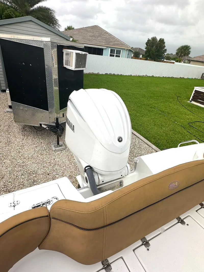 Slide: The Image of 2022 Sea Hunt Ultra 255 SE boat with Yamaha outboard motor in a residential yard. - 14
