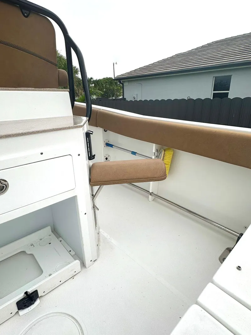 Slide: The Image of 2022 Sea Hunt Ultra 255 SE boat interior with tan seating and storage compartments. - 15
