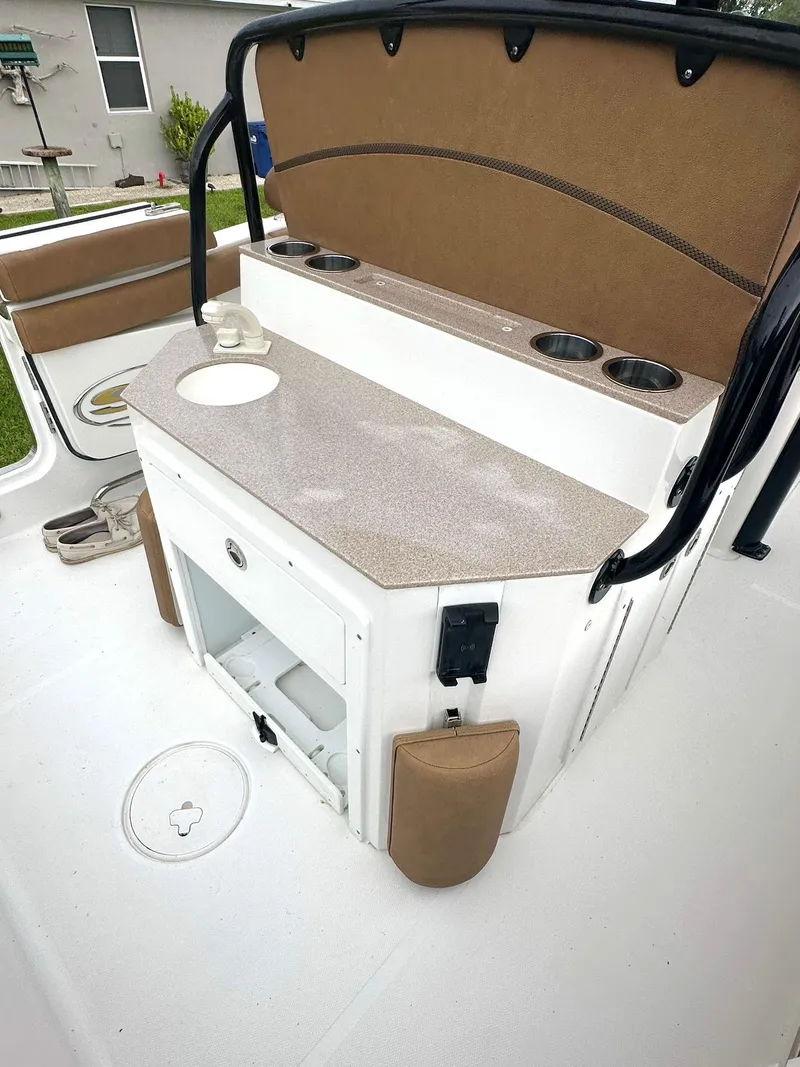 Slide: The Image of 2022 Sea Hunt Ultra 255 SE boat interior with storage and cup holders. - 16