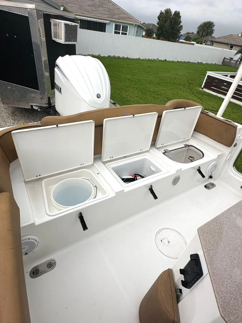 Slide: The Image of 2022 Sea Hunt Ultra 255 SE boat interior with open storage compartments and seating. - 18