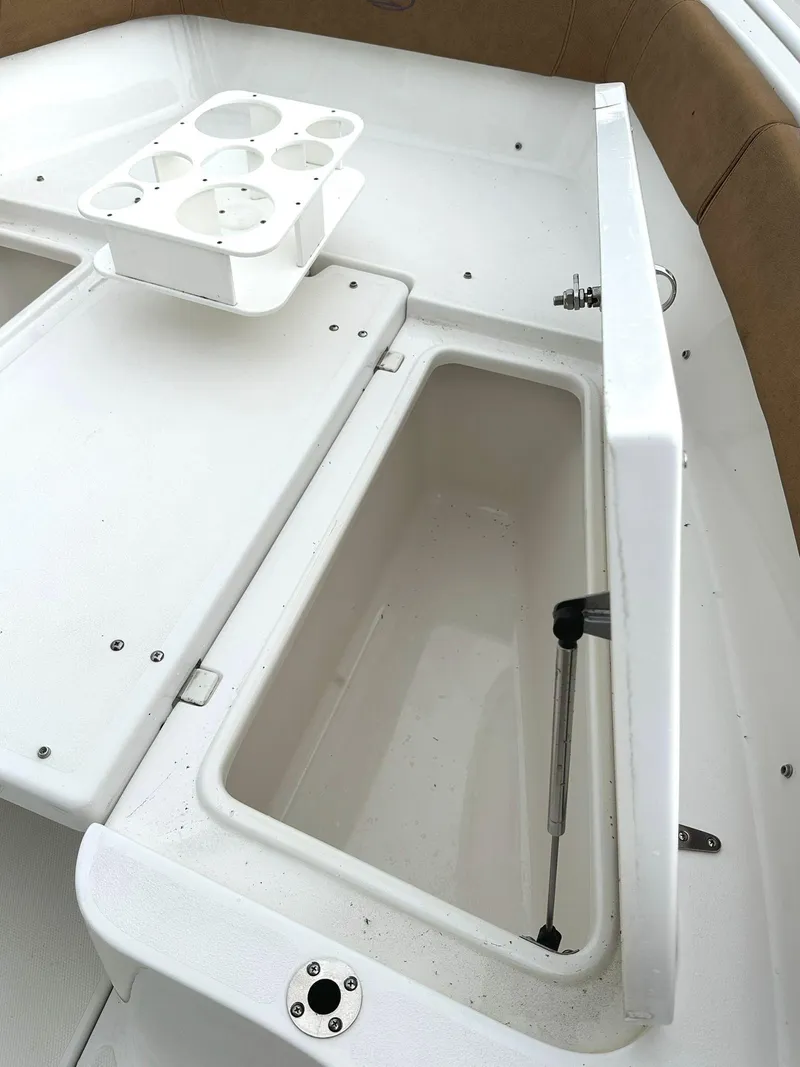 Slide: The Image of 2022 Sea Hunt Ultra 255 SE boat storage compartment with cup holders. - 24