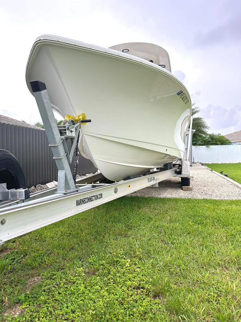 Slide: The Image of 2022 Sea Hunt Ultra 255 SE boat on trailer, parked on grass. - 3