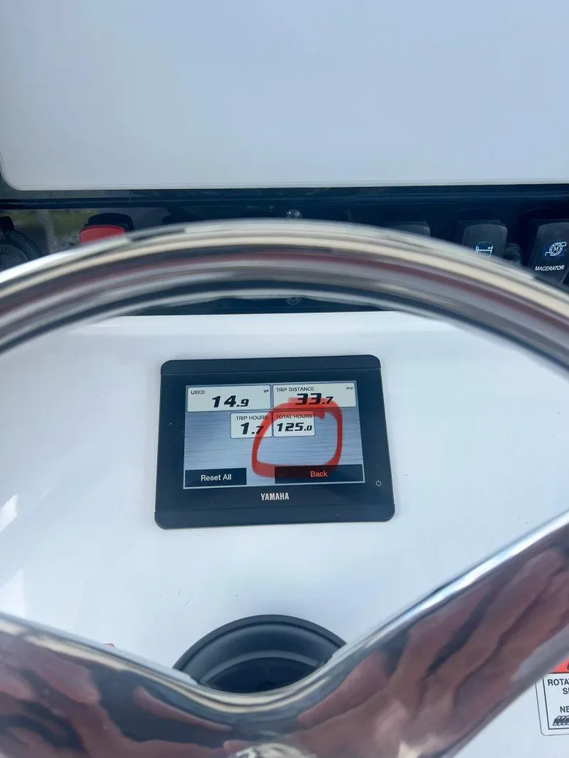 Slide: The Image of Steering wheel and display of 2022 Sea Hunt Ultra 255 SE boat, showing engine hours. - 31