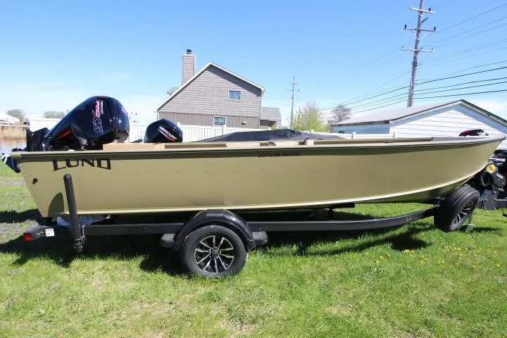 Slide: The Image of 2025 Lund 2075 Alaskan Tiller boat on trailer, parked on grass. - 0