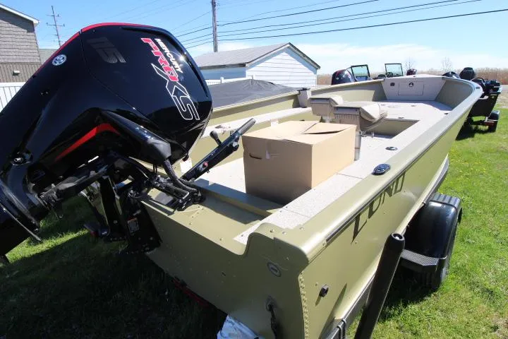 Slide: The Image of 2025 Lund 2075 Alaskan Tiller boat with powerful outboard motor, parked on grass. - 1