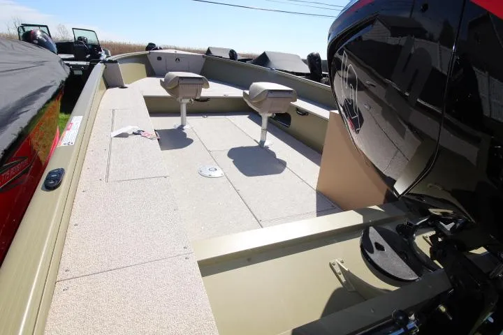 Slide: The Image of 2025 Lund 2075 Alaskan Tiller boat interior with seating and motor, viewed from the rear. - 2