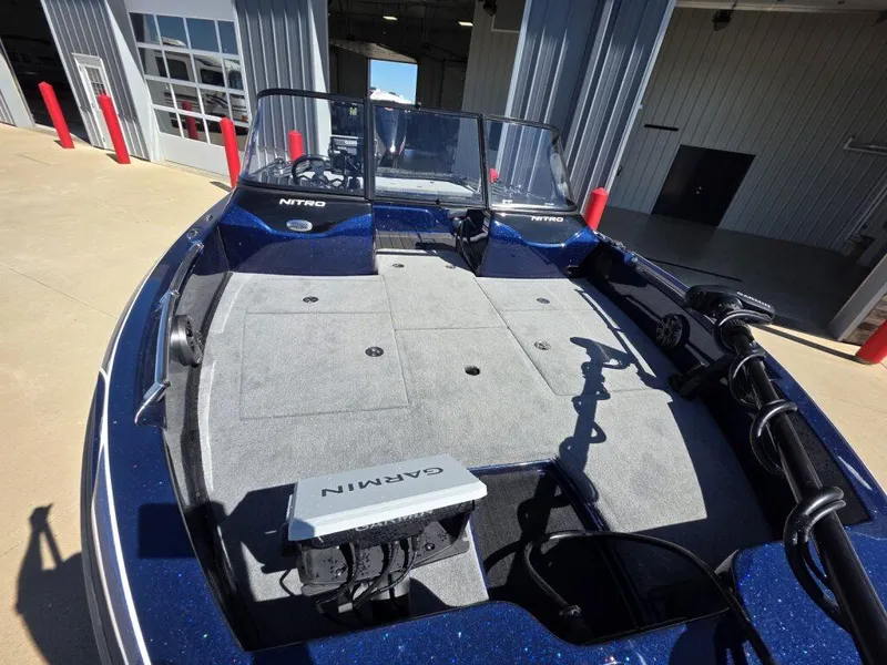 Slide: The Image of 2025 Nitro ZV19 Sport Pro boat with Garmin equipment, parked outside a garage. - 8